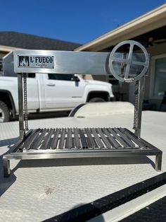 a metal bench sitting in front of a white truck