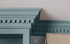 two blue fireplaces are next to each other in a room with white walls and green trim