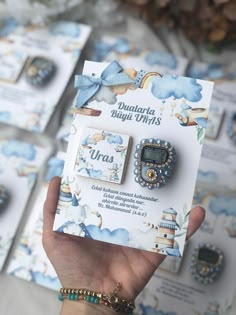 a person holding up some brooches in front of a box with other brooches on it