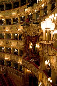 an ornately decorated auditorium with chandeliers and candles