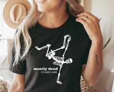 a woman wearing a mostly dead skeleton t - shirt