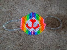 a multicolored beaded bracelet with a smiley face on it