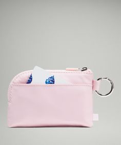 a pink purse with a card holder and keychain hanging from it's side