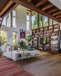 a living room filled with lots of furniture and bookshelves next to a fire place