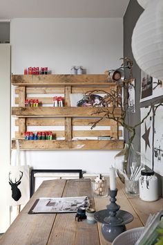 a wooden table sitting in front of a wall mounted shelf filled with crafting supplies