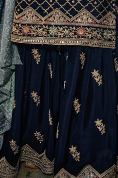 This Navy Blue Party Wear Sharara Gharara Suit flaunts sophistication with zari, resham, badla, and sequence work along the kameez. Accented by a chinnon silk embroidered sharara palazzo bottom, santoon lining, and sequence embroidered chinon silk dupatta, this ensemble is perfect for weddings and other special events. Kameez chinon silk with heavy embroidery & khatali work Sharara chinon silk with heavy embroidery front and back Dupatta chinon silk with embroidery work & digital print Side slit Navy Blue Pakistani Dress, Navy Blue Sharara, Blue Pakistani Dress, Sharara Suit Pakistani, Phulkari Pants, Blue Sharara, Lucknowi Kurta, Navy Blue Party, Gharara Suits