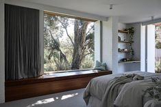 a bedroom with a large window overlooking the trees