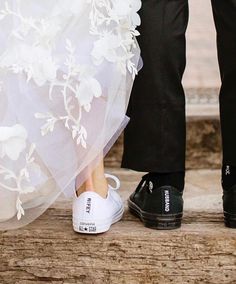 the bride and groom are standing next to each other in their wedding shoes with white flowers on them