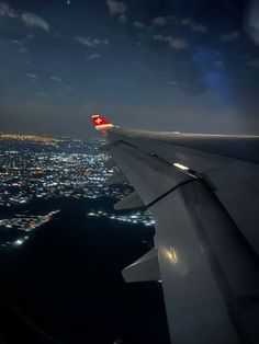 the wing of an airplane flying over a city at night