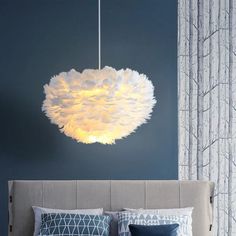 a bedroom with blue walls and a large white light fixture hanging from the ceiling over the bed