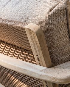 a close up of a wooden chair with woven fabric on the back and seat cushion