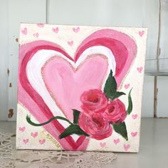 a pink heart with roses painted on it