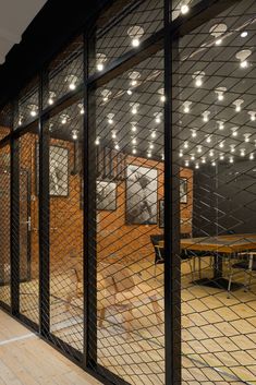 the inside of an office building with glass walls and steel mesh partitions on each side