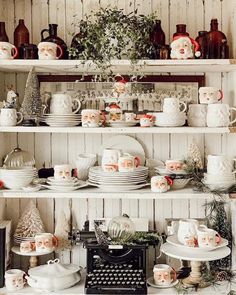 shelves filled with white dishes and christmas decorations