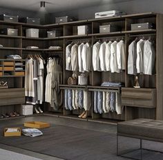 an organized closet with clothes, shoes and boxes on the floor next to a bench