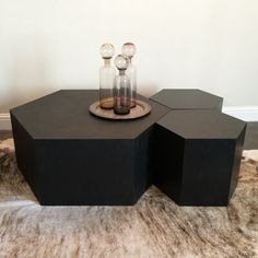 two glass bottles sitting on top of a black table next to a furnishing