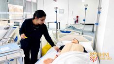 a woman standing next to a dummy in a hospital