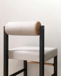 a white and black chair sitting on top of a hard wood floor next to a wall