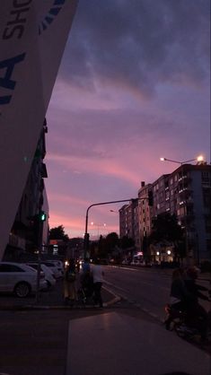 some people are riding their bikes down the street at sunset or dawn in an urban setting