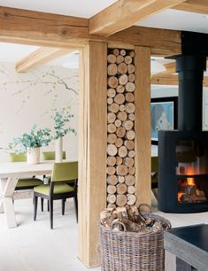 a fireplace with logs stacked on it in a living room next to a table and chairs