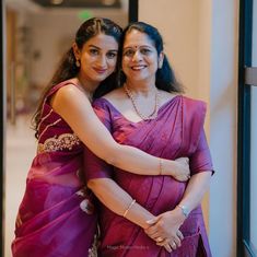 two women in sari hugging each other