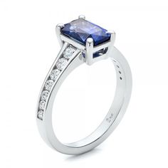 Custom Blue Sapphire and Diamond Engagement Ring Classic Blue Birthstone Ring With Prong Setting, Blue Formal Rings With Side Stones, Formal Blue Rings With Side Stones, Classic Blue Gemstone Birthstone Ring, Blue Sapphire Channel Set Jewelry, Blue Birthstone Ring With Emerald Cut Center Stone, Blue Emerald Cut Birthstone Ring With Center Stone, Blue Tanzanite Emerald Cut Ring, Blue Rings With Side Stones And Round Cut