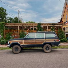 a brown and black jeep parked in front of a house