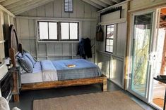 a bed sitting inside of a bedroom on top of a wooden floor next to a doorway