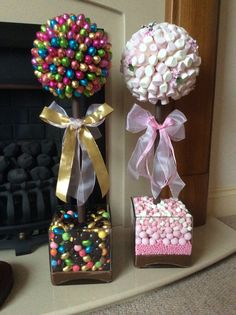 three small vases with candy and candies in them sitting on a fireplace mantel