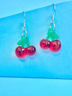 Beautiful red cherry dangle earrings. brilliant red and green colour.  The hook is made of plated sterling silver to protect your ears and the cherry is made of resin.  They come well presented and wonderful for a present for a friend, family, your loved one or a treat for you.  Thank you for taking the time to look at my earrings and please visit my shop for more original designs. Bespokedanglers.  Sharlene xx  For Fun, Funky, Quirky and original designs, please visit my shop. Bespokedanglers Trendy Red Sterling Silver Jewelry, Cherry Dangle Earrings With Ear Wire, Cherry Colored Drop Earrings With Ear Wire, Cherry Drop Earrings With Ear Wire, Trendy Red Resin Earrings, Cherry Round Earrings For Gift, Cherry Colored Round Earrings For Gift, Red Resin Drop Earrings, Earrings Funky