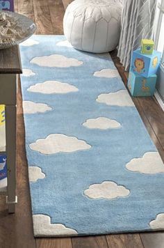 a blue rug with white clouds on it in a living room next to a window