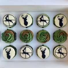 twelve cupcakes decorated with green frosting and black deer silhouettes on them