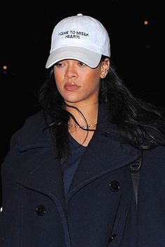 a woman wearing a white hat and black coat