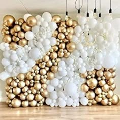 balloons are arranged in the shape of letters on a wall with gold and white balls