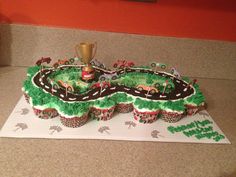 cupcakes are arranged in the shape of a race track with cars on it