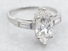 an oval cut diamond ring with baguetts on the sides