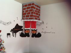 a room decorated for christmas with decorations on the wall and a piano in the corner