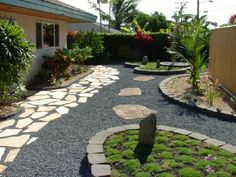 a stone path leads to a house with landscaping in the foreground and trees on the far side