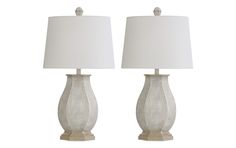 two lamps with white shades on each lamp and one is turned off to the side