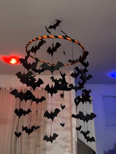 a wind chime decorated with bats hanging from it's sides in front of a window