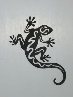 a gecko painted on the side of a white wall with black and white designs