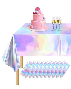 a table topped with a pink cake next to wine glasses and napkins on top of it