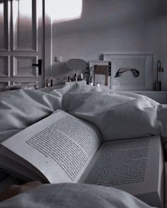 an open book sitting on top of a bed