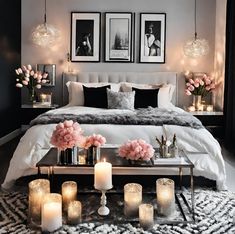 a bedroom decorated in black and white with candles on the coffee table next to the bed