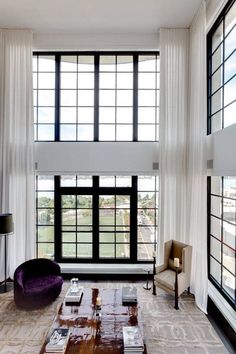 a living room with high ceilings and large windows