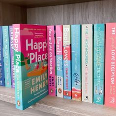 a row of books sitting on top of a wooden shelf