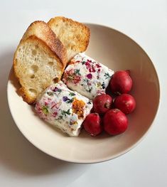 a plate with bread, fruit and cranberries on it