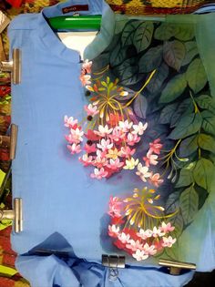 a blue shirt with flowers painted on it