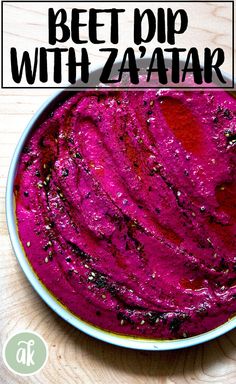 beet dip with zaatar in a bowl on top of a wooden table