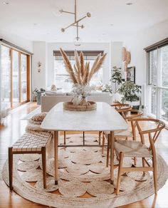 a dining room table surrounded by chairs and rugs